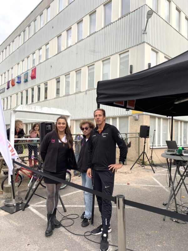 tre personer framför skola
