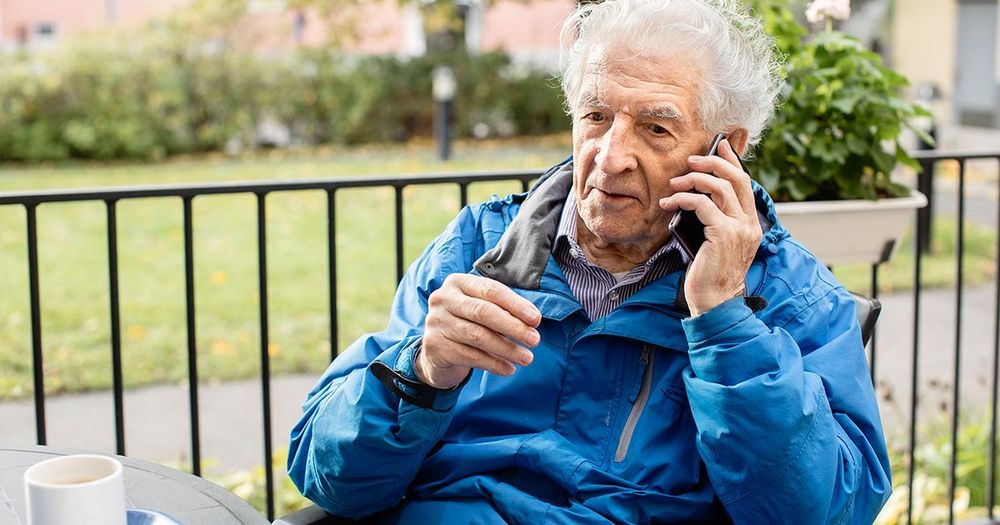 äldre man talar i mobil