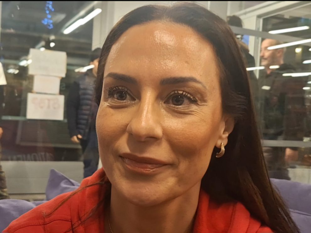 Kvinna med mörkt långt hår och bruna ögon, med en röd tröja.