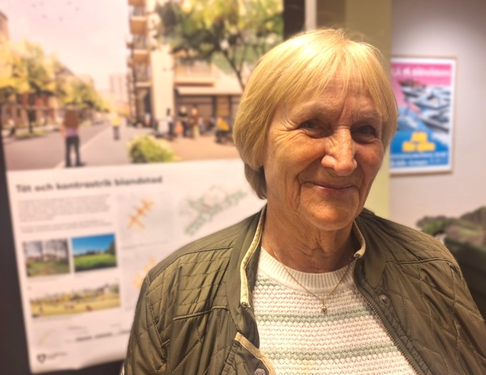 En äldre kvinna i ljust kort hår, med grön jacka och vit tröja.