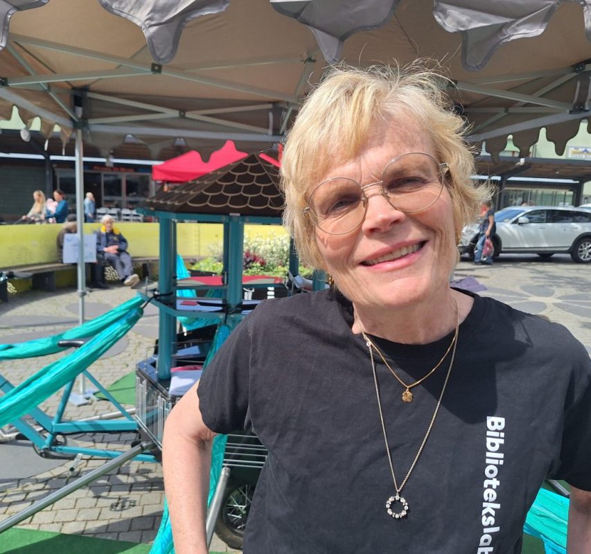 Vit äldre kvinna med kort ljust år och svart tshirt.