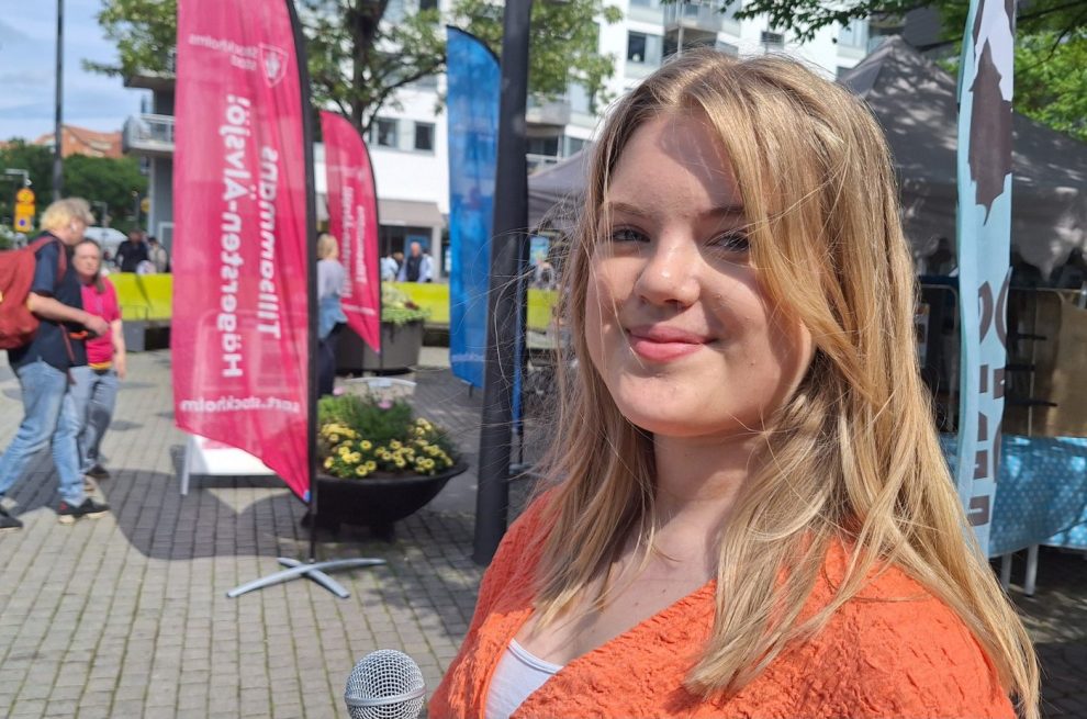 En vit kvinna i rödlätt långt hår, orange tröja 