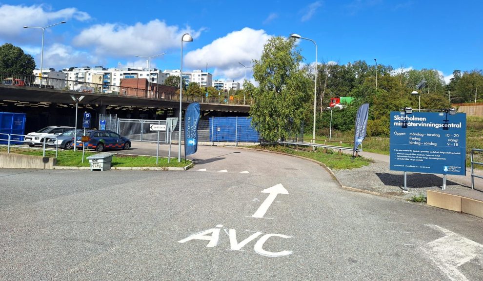 En asfalterad väg där det står ÅVC och en pil målat i vitt på marken.