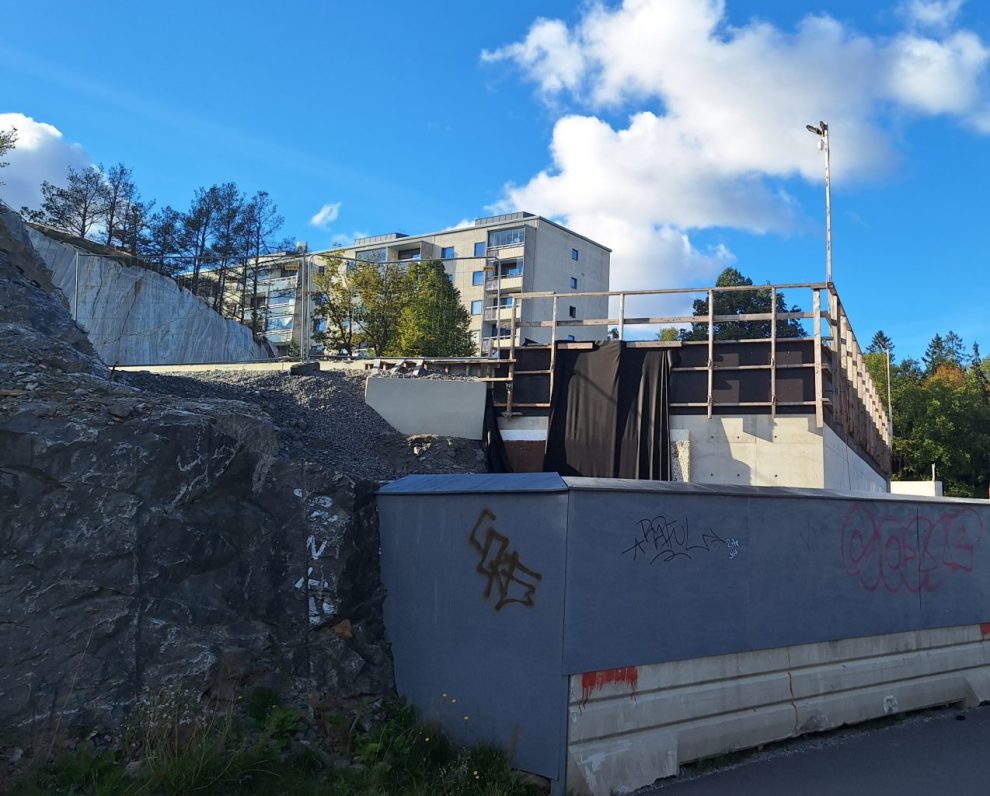 En byggarbetsplats med höghus i bakgrunden.