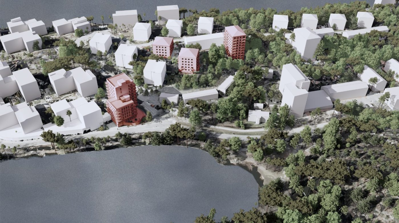 Visaliering uppifrån över ett område där alla hus är vita utom de nya tilltänkta byggnaderna som är röda. I nederkant syns en vik med vatten.