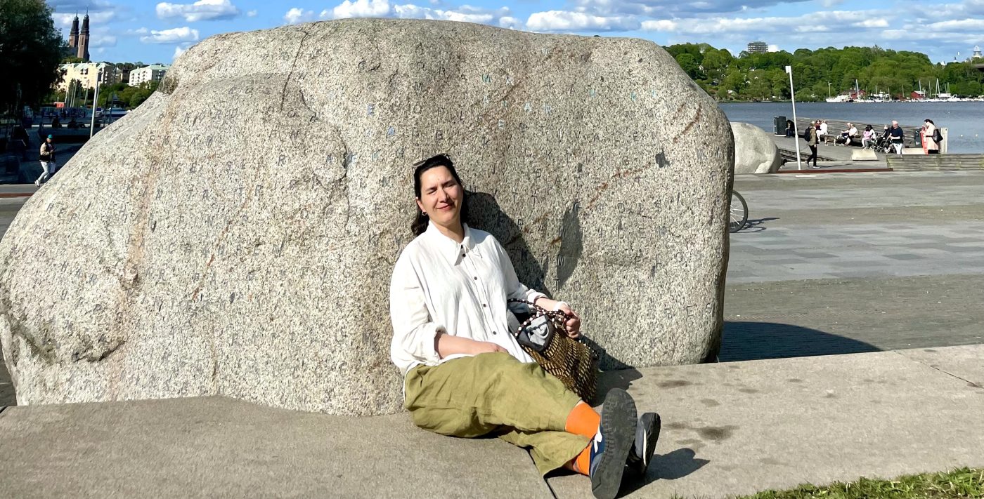 kvinna framför stor sten